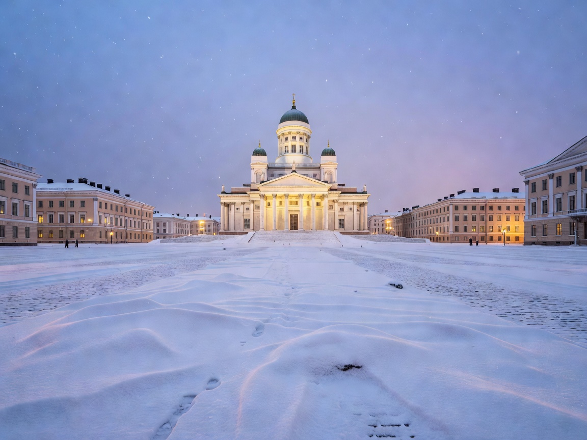 Snow-covered Senate Square and Helsinki Cathedral illuminated at twilight